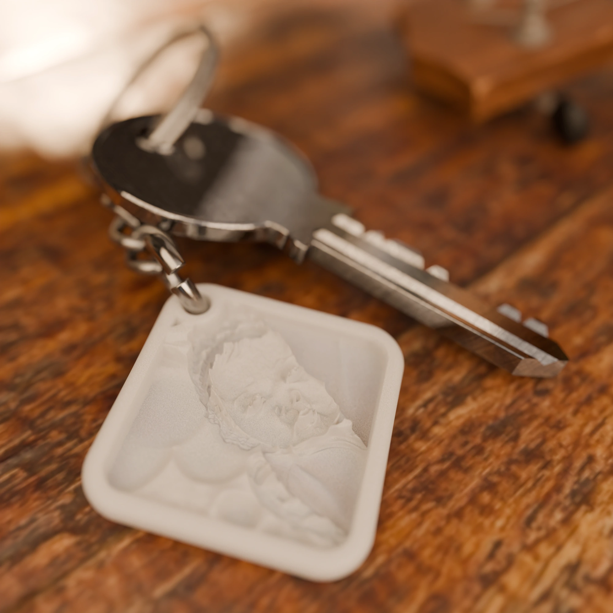 Glimery square photo keychain with a baby photo, lying on a table, showing the relief of the photo.